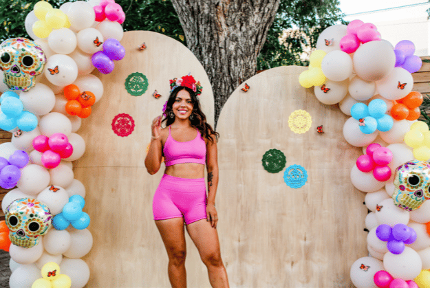 Guest under a colorful balloon arch backdrop