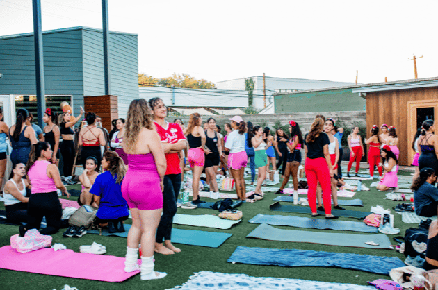 Large fitness class gathered on the turf lawn