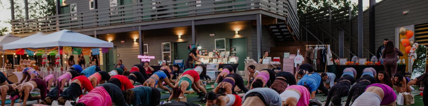 A large outdoor yoga class on the Webber East lawn in front of the lodging building