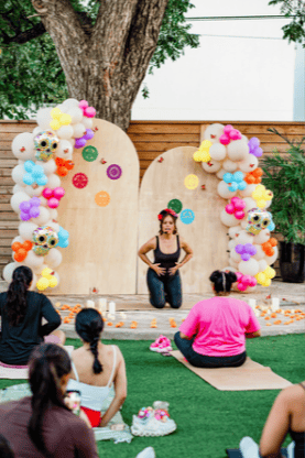 Wellness instructor beneath a balloon arch